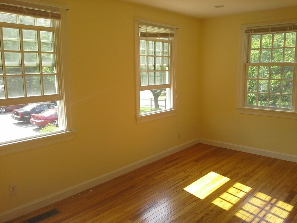 123 Jericho Road, Unit 123 Weston, MA 02493 - Photo 9 of 12 a view of an empty room with wooden floor and a window