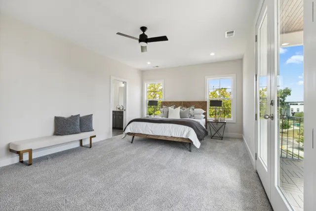 a bedroom with a bed a couch and ceiling fan