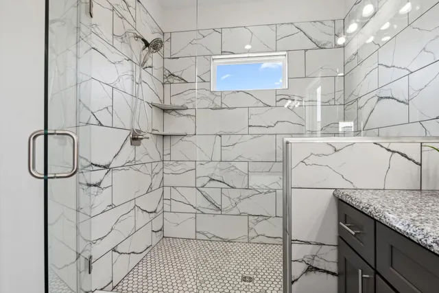 a bathroom with a granite countertop shower and a sink
