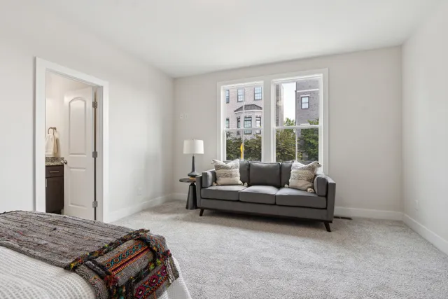 a bedroom with a bed a couch and a window