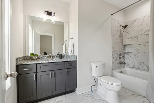 a bathroom with a granite countertop toilet a sink and a bathtub