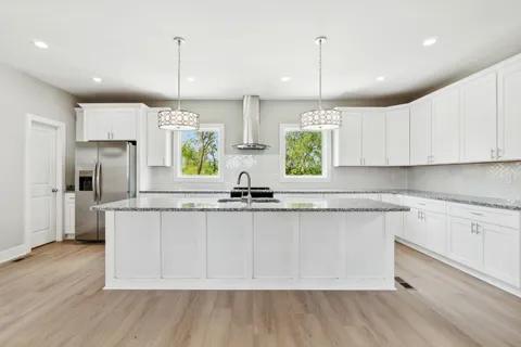 a kitchen with stainless steel appliances granite countertop a sink a stove a refrigerator and window