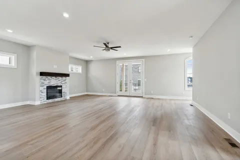 a view of empty room with wooden floor and fireplace