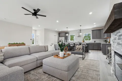 a living room with furniture kitchen view and a window