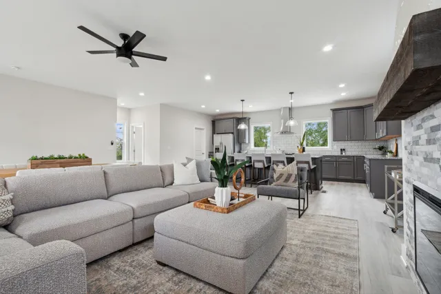 a living room with furniture kitchen view and a window