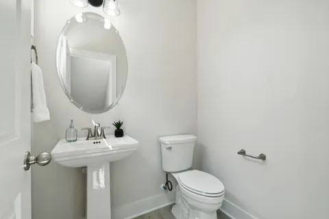 a bathroom with a toilet sink and mirror