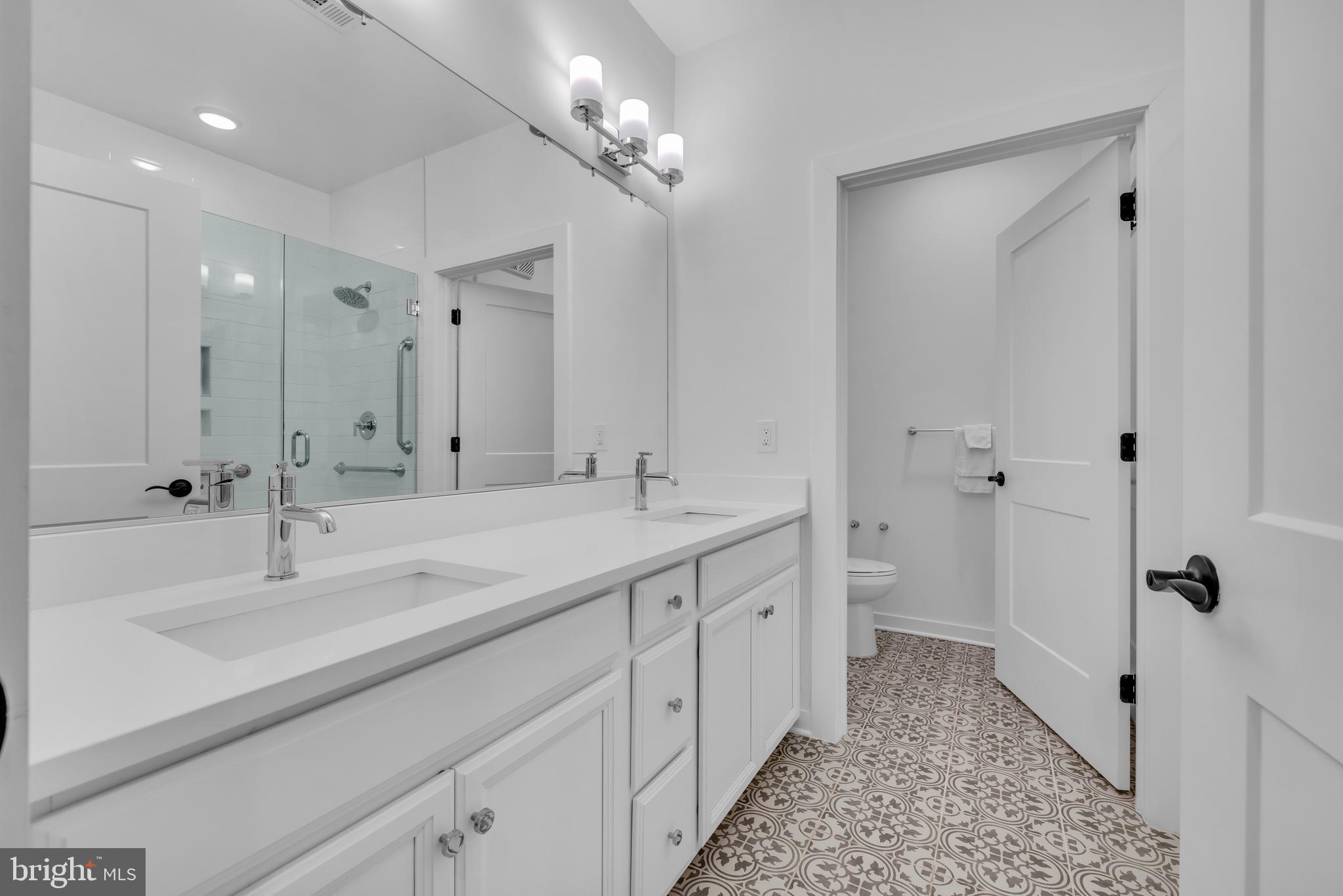 78 Old Mill Bottom Road North, Unit 101 Annapolis, MD 21409 - Photo 12 of 29 a spacious bathroom with a double vanity sink a large mirror and shower