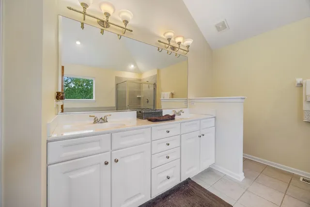 a bathroom with a double vanity sink mirror and bathtub