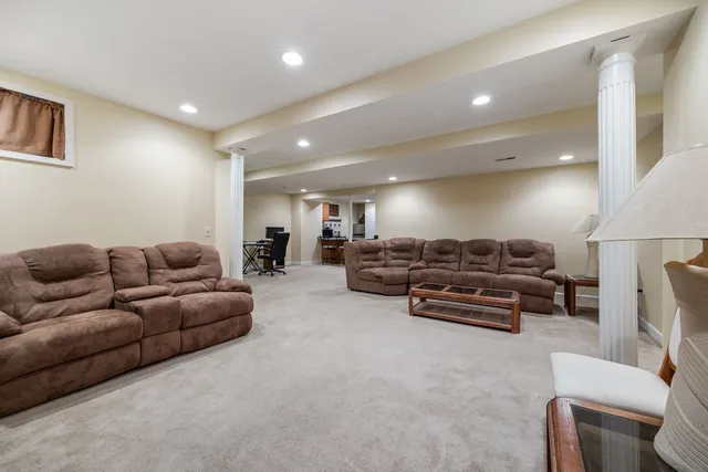 a living room with furniture a couch and a dining table with wooden floor