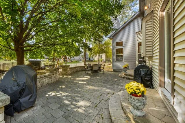 a view of a patio with table and chairs potted plants and large tree