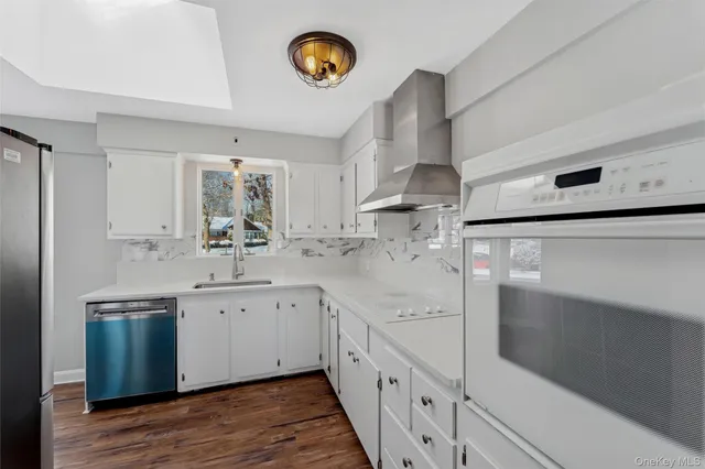 a kitchen with white cabinets and sink