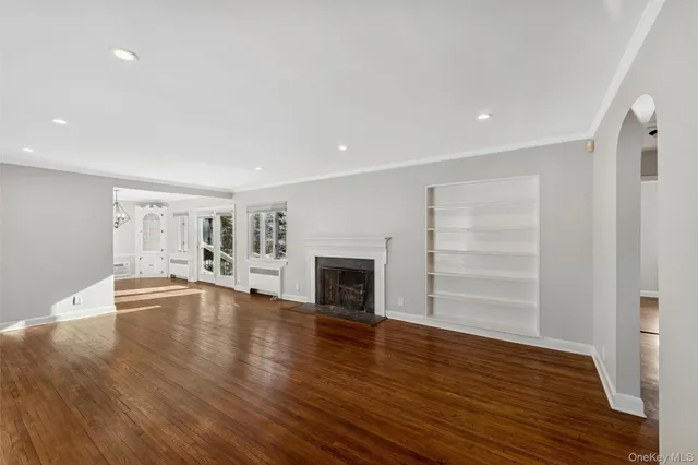 a view of empty room with a fireplace and wooden floor