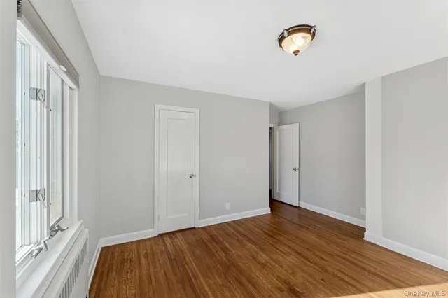 a view of a livingroom with wooden floor and a window