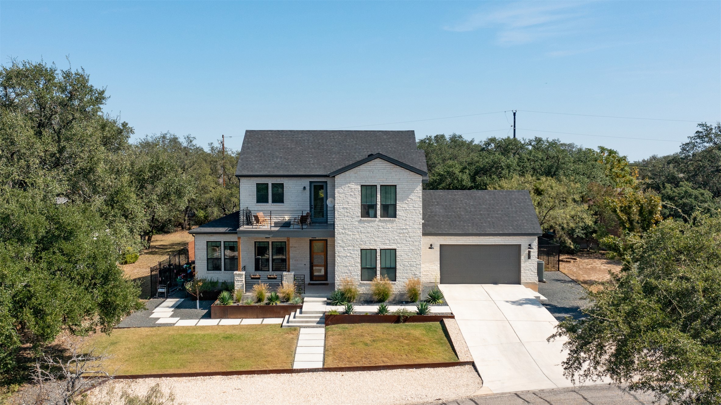 a view of house with yard outdoor seating and covered with trees