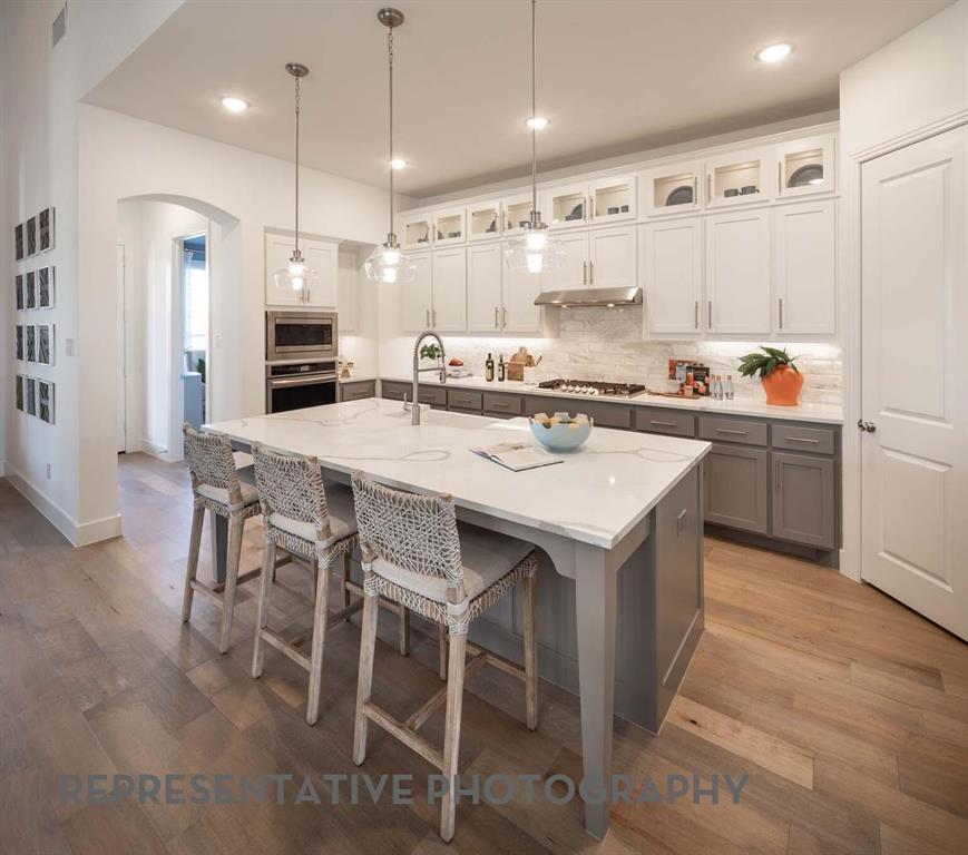 8903 Wildberry Road Oak Point, TX 75068 - Photo 6 of 31 a kitchen with kitchen island granite countertop a table and chairs in it