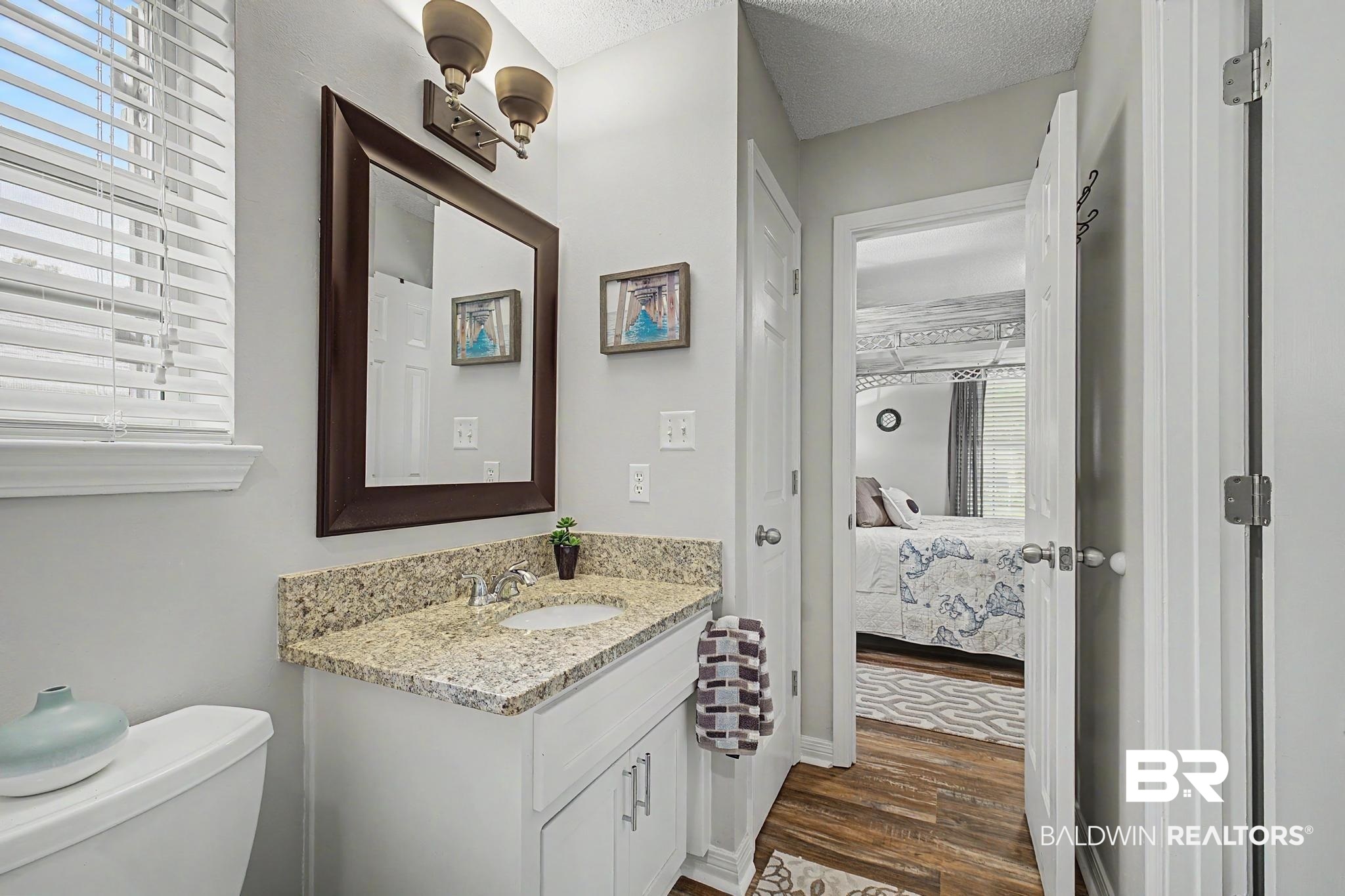 2808 Pine Ridge Drive Lillian, AL 36549 - Photo 22 of 47 Bathroom featuring a single vanity with a granite countertop, undermount sink, and brushed nickel faucet
