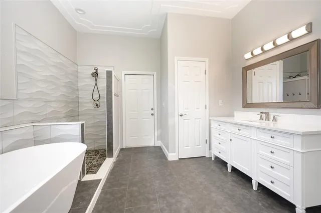 a bathroom with a tub a sink double vanity and a shower