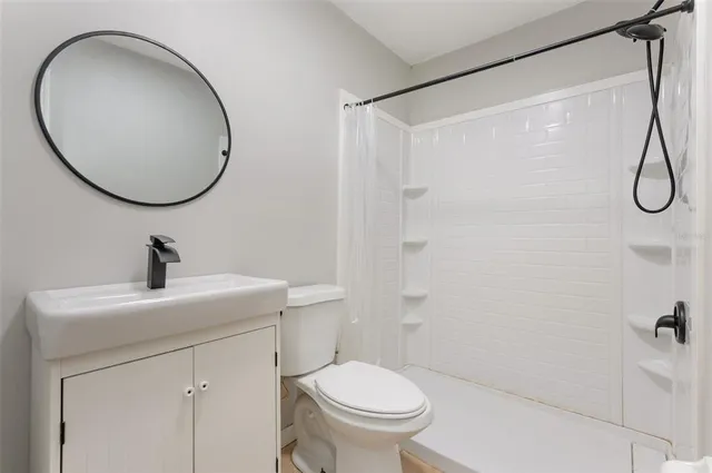 a bathroom with a sink toilet and a mirror