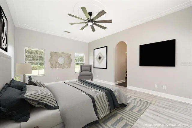 a bedroom with a bed a mirror on the wall and a flat screen tv