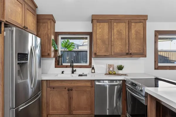 a kitchen with stainless steel appliances granite countertop a refrigerator sink and stove