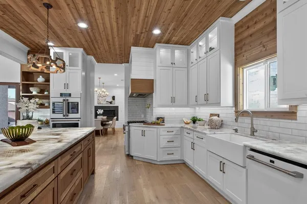 a kitchen that has a lot of cabinets in it and wooden floor