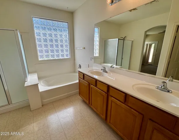 a spacious bathroom with double vanity two mirror and a bathtub