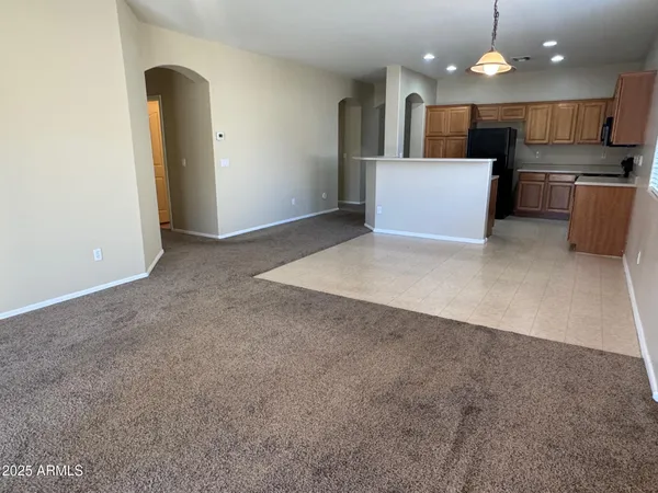a view of kitchen with refrigerator and white cabinets