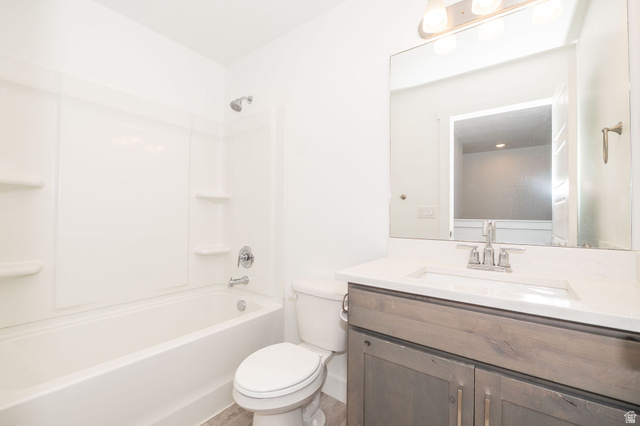 46 West 460 Smithfield, UT 84335 - Photo 21 of 31 Full bathroom featuring a white tub and shower combination with integrated shelving, a sleek vanity with a light-toned countertop and an undermount sink, and wood-finish flooring