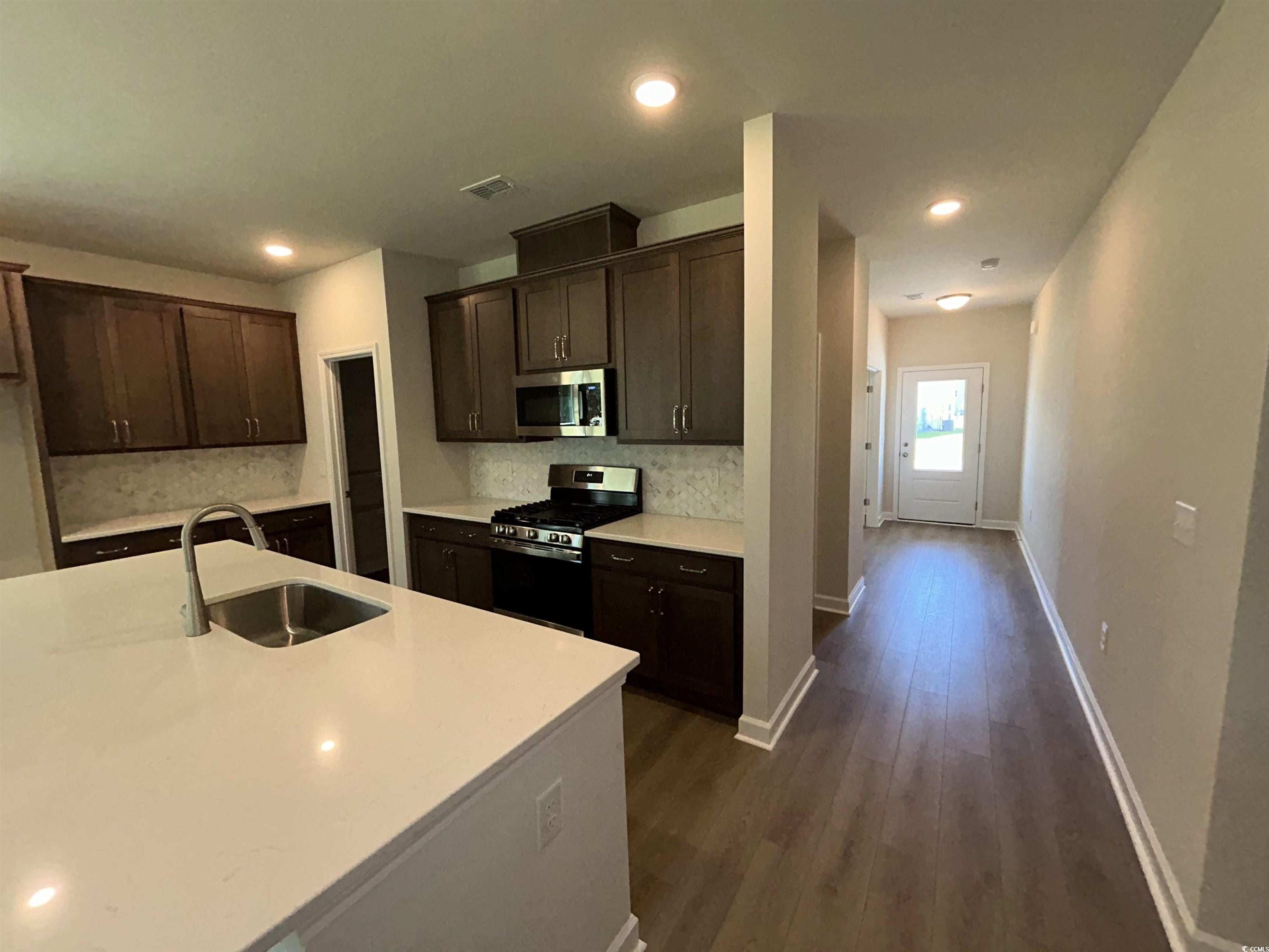 3068 Palma Way Myrtle Beach, SC 29579 - Photo 12 of 30 Kitchen featuring stainless steel appliances, decorative backsplash, dark brown cabinets, dark wood-style floors, and recessed lighting