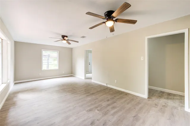 a view of a room with a ceiling fan and window