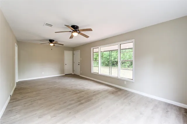 a view of a livingroom with a ceiling fan and window