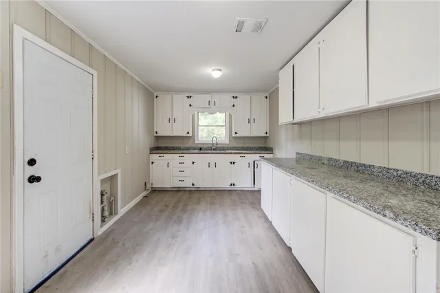 a kitchen with granite countertop white cabinets and white appliances