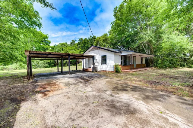 a view of house with backyard and outdoor seating