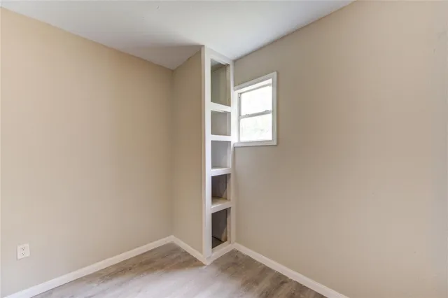an empty room with a window and a fan