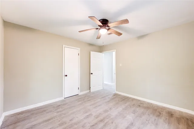 a view of room with a ceiling fan and wooden floor
