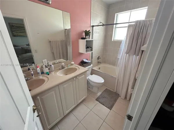 a bathroom with a sink a toilet a mirror and shower