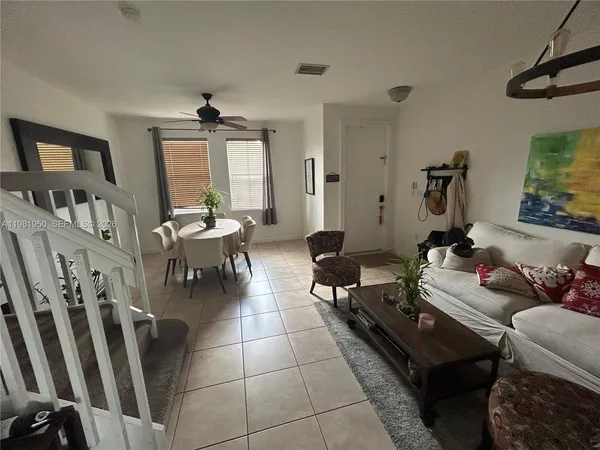 a living room with furniture a flat screen tv and a window