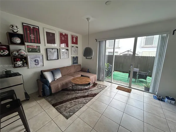 a living room with furniture and a floor to ceiling window
