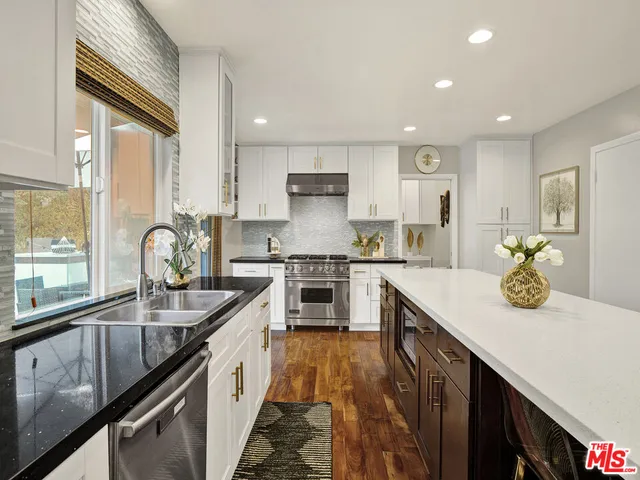 a kitchen with stainless steel appliances granite countertop sink stove and cabinets