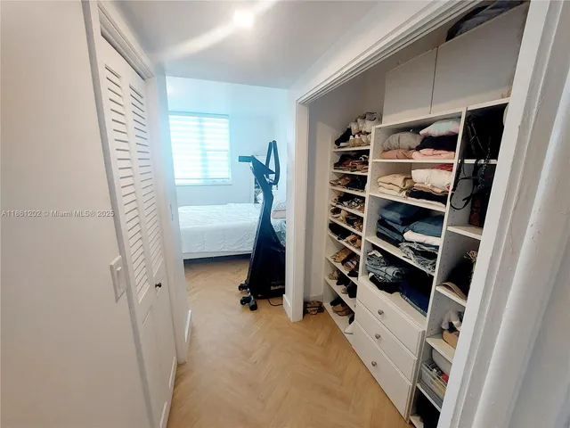 a view of walk in closet with clothes and shoes