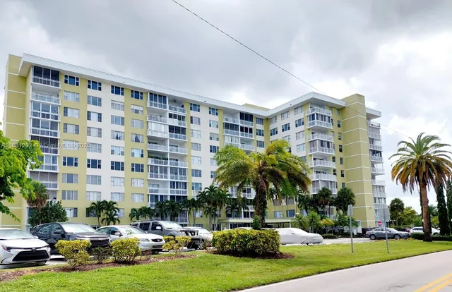 a front view of building with yard and swimming pool