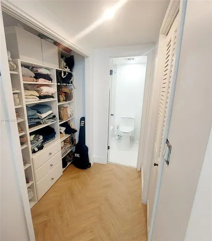 a view of walk in closet with clothes and shoes