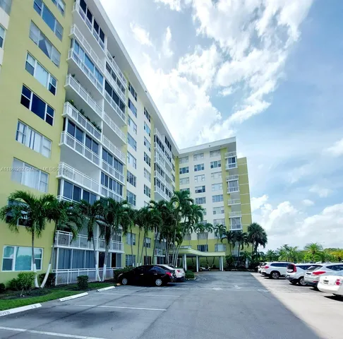 a city street lined with parked cars and buildings
