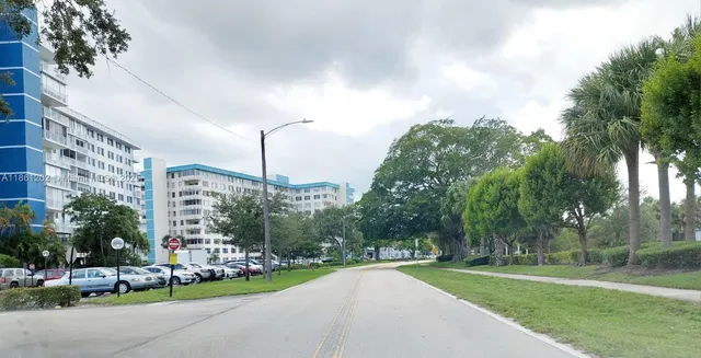 a view of a city with tall buildings and a cars park side of the road