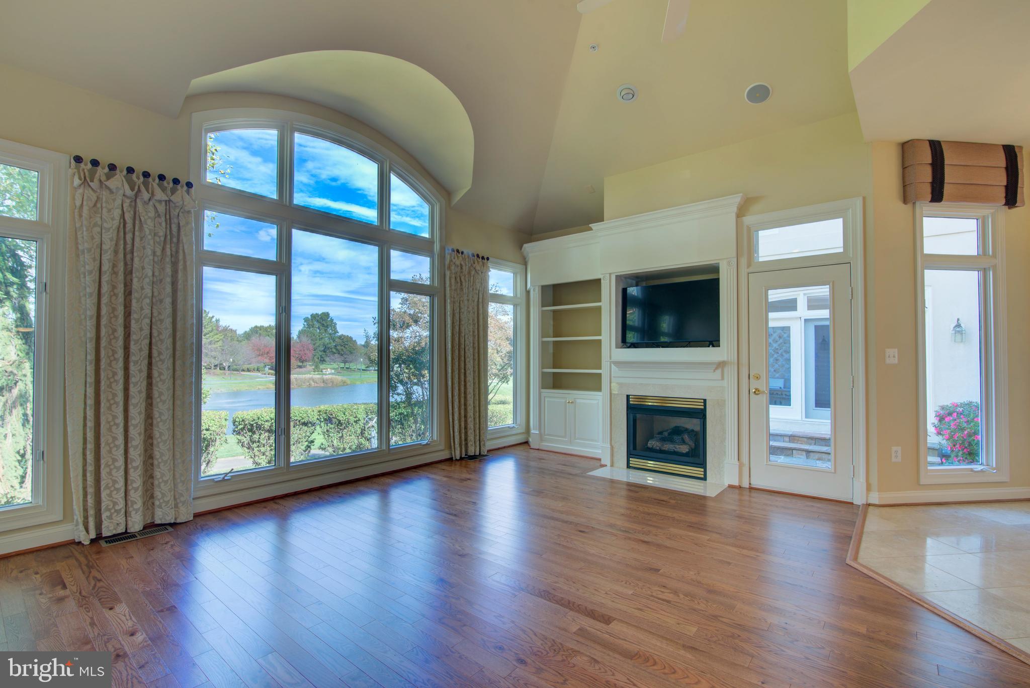 43462 Firestone Place Leesburg, VA 20176 - Photo 11 of 80 an empty room with wooden floor fireplace and windows