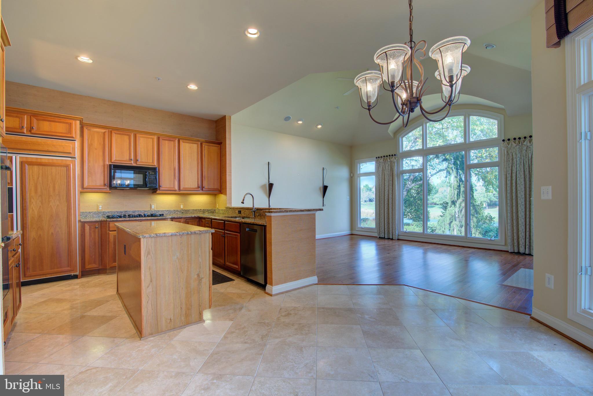 43462 Firestone Place Leesburg, VA 20176 - Photo 14 of 80 a kitchen with stainless steel appliances granite countertop a stove top oven a large window with the view of kitchen
