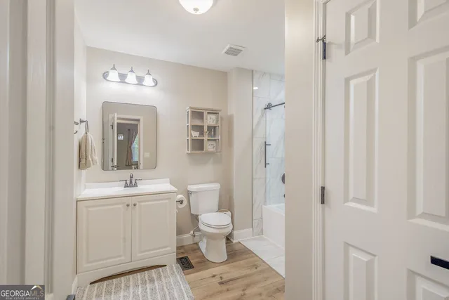 a bathroom with a sink a toilet and a large mirror