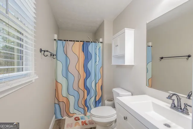 a white toilet sitting next to a bathroom sink and a shower