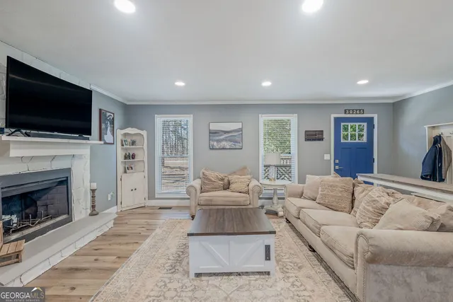 a living room with furniture a flat screen tv and a fireplace