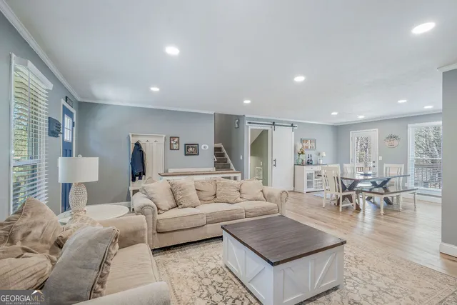a living room with furniture and a dining table with wooden floor